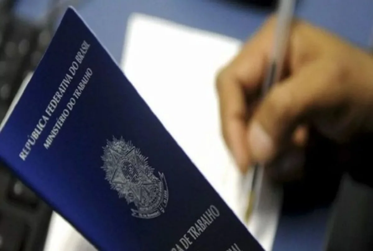 Pessoa segurando carteira de trabalho - Metrópoles